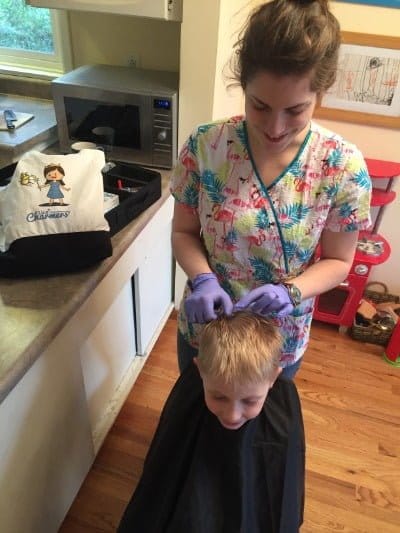 head lice treatment on a young boy in his home