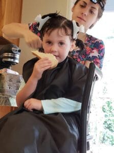 lice treatment and lice removal on a young girl in home