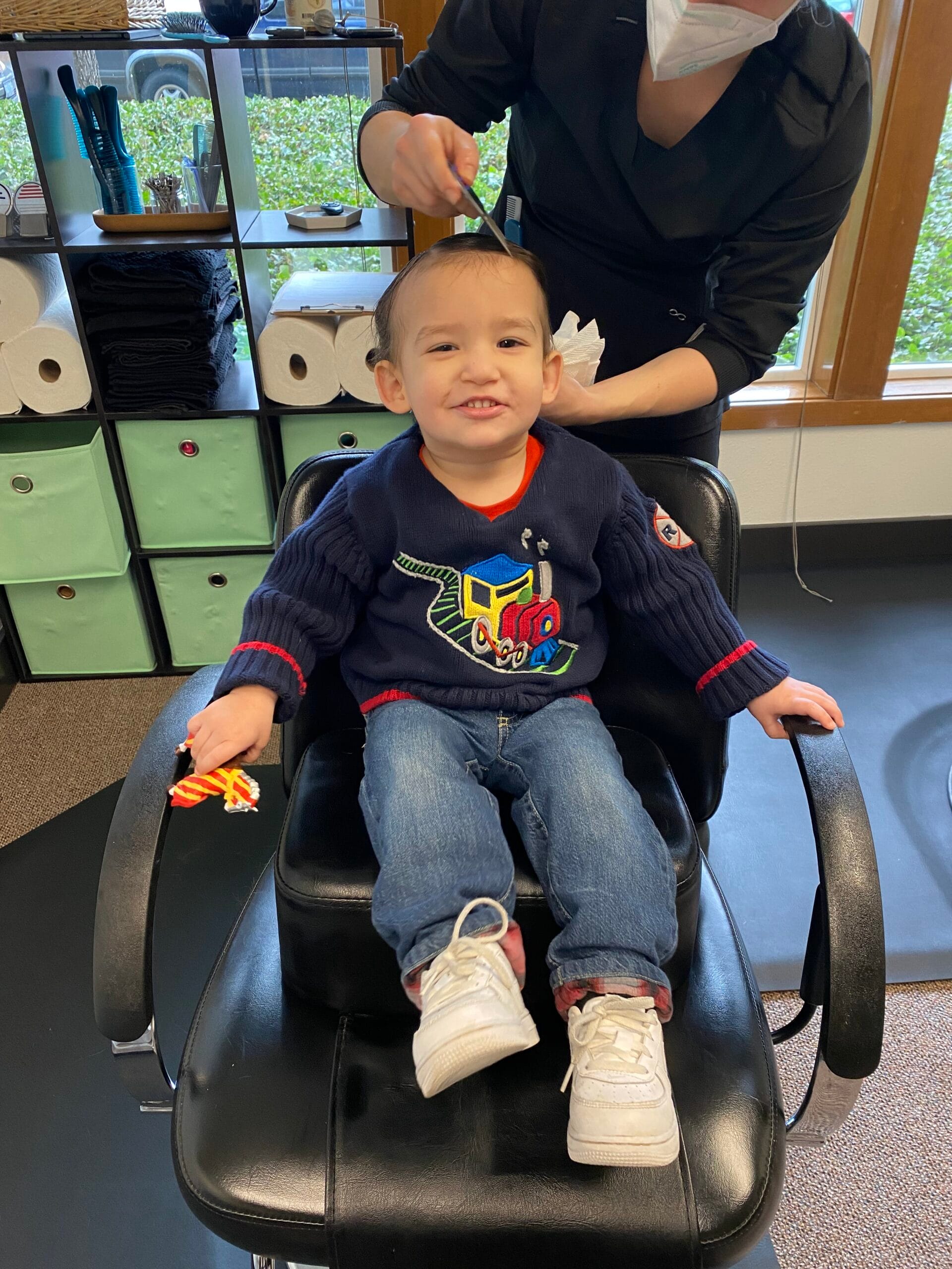 Smiling child having hair lice combed at a lice clinic