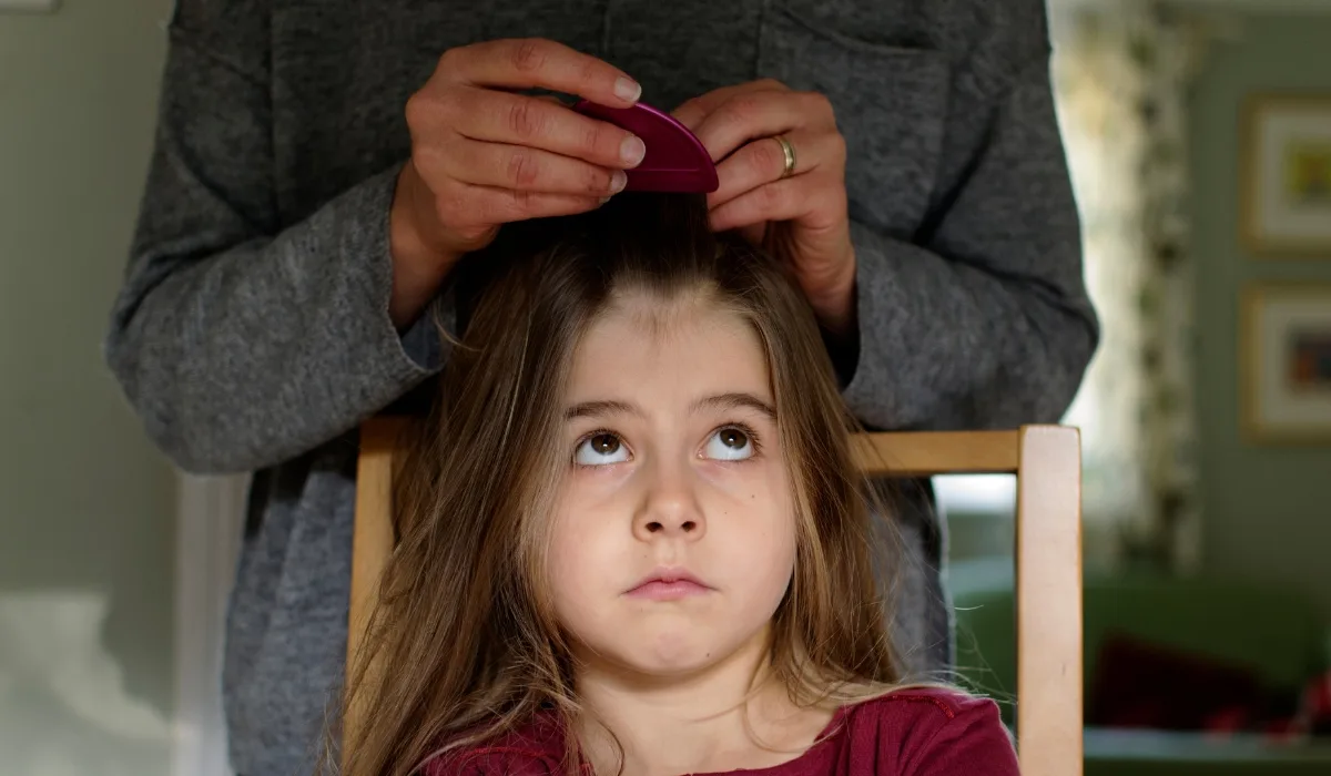 child with head lice treatment at home in