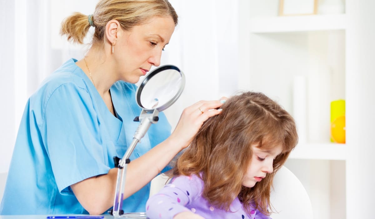 Seattle lice specialist examines child's hair for head lice removal treatment at a local clinic